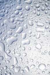 Photo of Water drops on light glass surface, top view