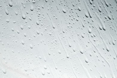 Photo of Water drops on light glass surface, top view