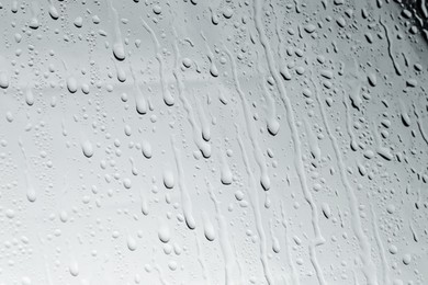 Water drops on light glass surface, closeup