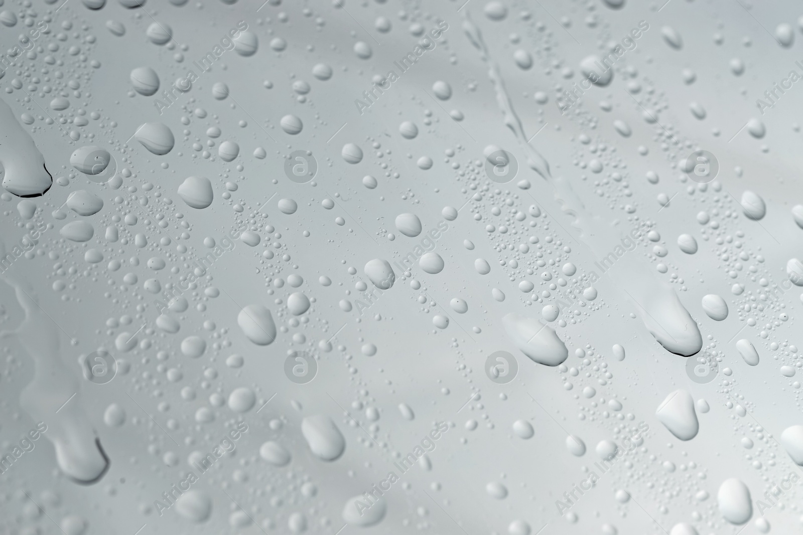 Photo of Water drops on light glass surface, top view