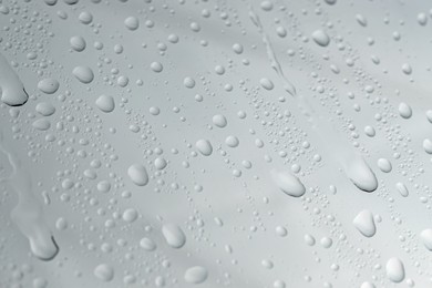 Water drops on light glass surface, top view