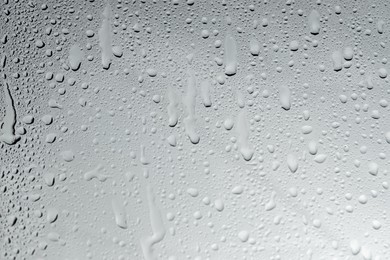 Photo of Water drops on light glass surface, top view