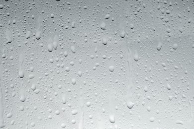 Photo of Water drops on light glass surface, top view