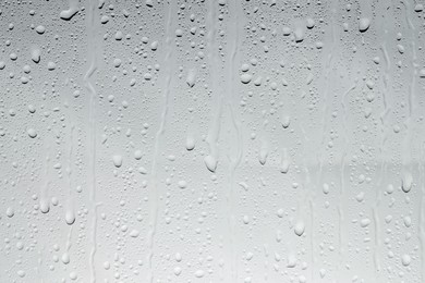 Photo of Water drops on light glass surface, top view