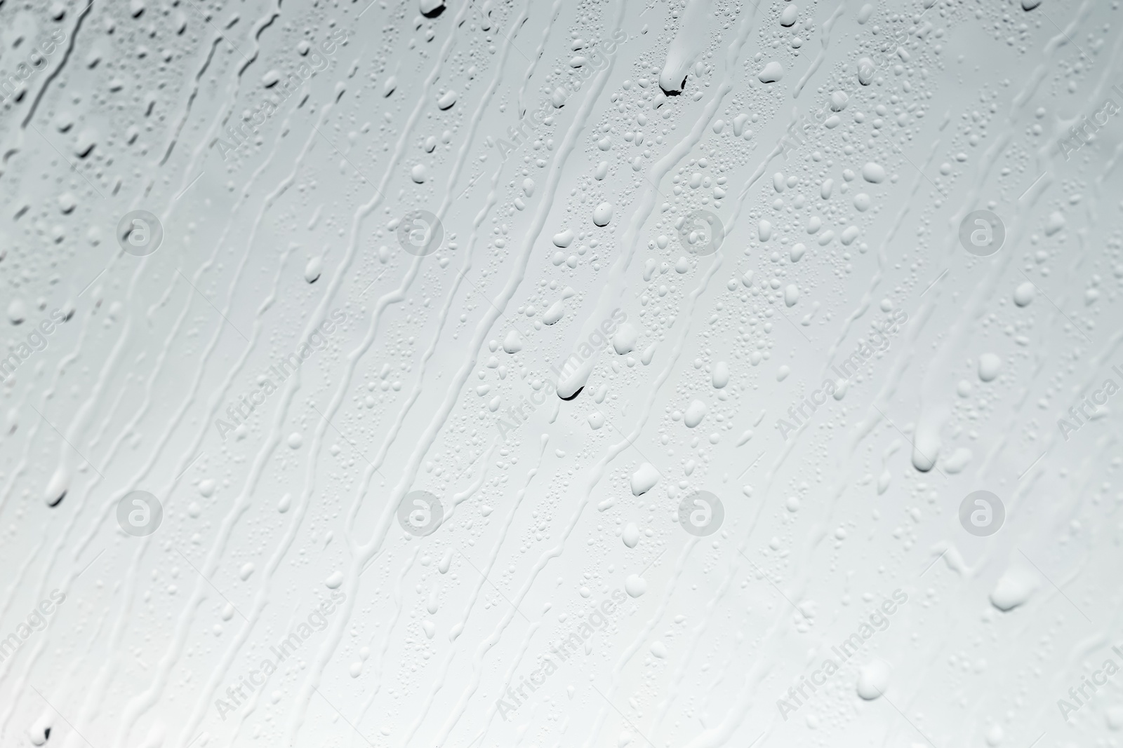 Photo of Water drops on light glass surface, top view