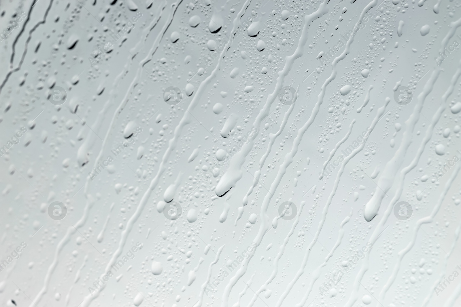 Photo of Water drops on light glass surface, top view