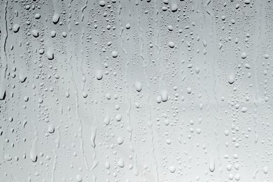 Photo of Water drops on light glass surface, top view