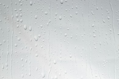 Water drops on light glass surface, top view