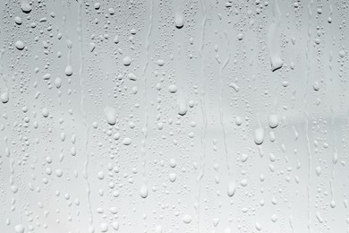 Photo of Water drops on light glass surface, top view