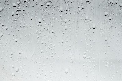 Water drops on light glass surface, top view