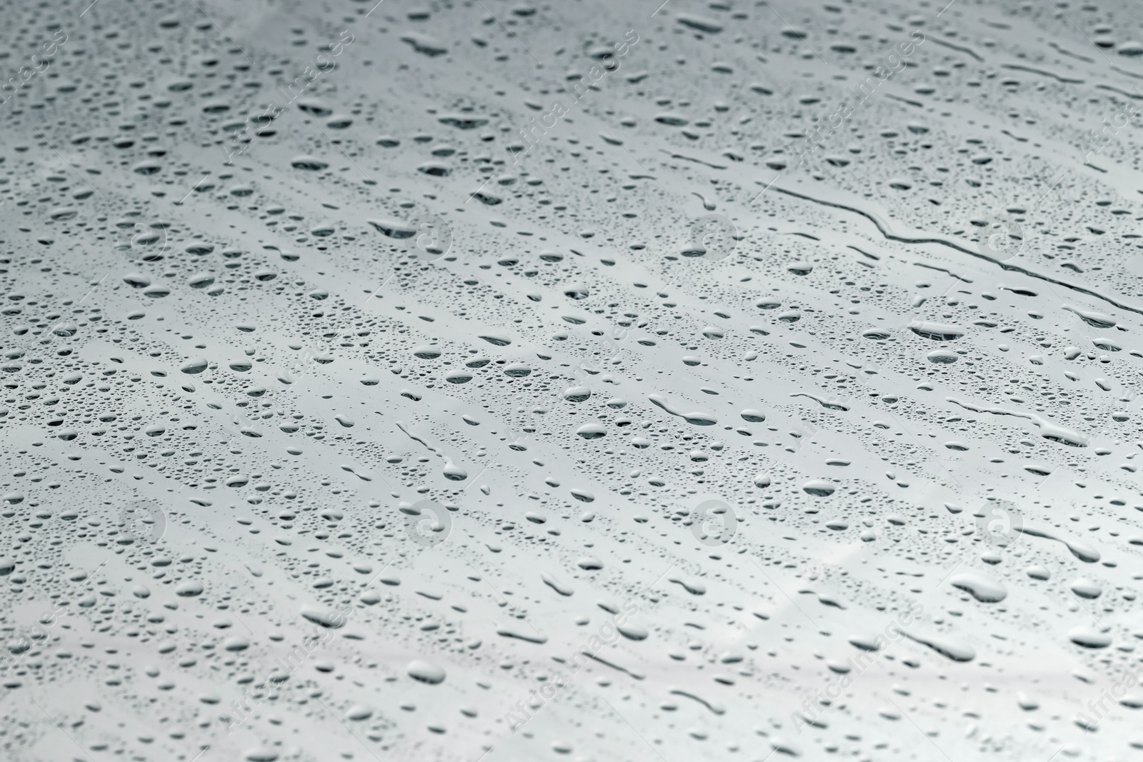 Photo of Water drops on grey glass surface, closeup