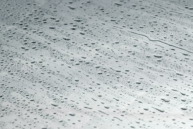 Water drops on grey glass surface, closeup