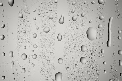 Photo of Water drops on grey glass surface, top view