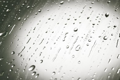 Water drops on grey glass surface, closeup