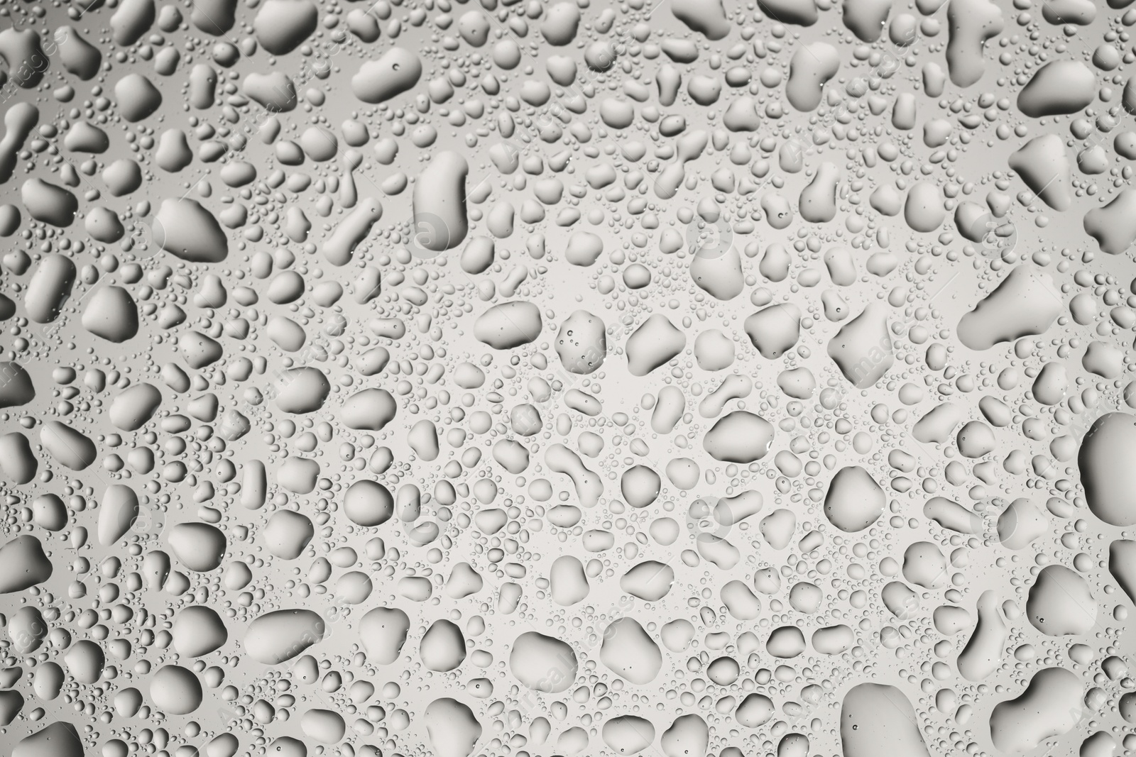 Photo of Water drops on grey glass surface, top view