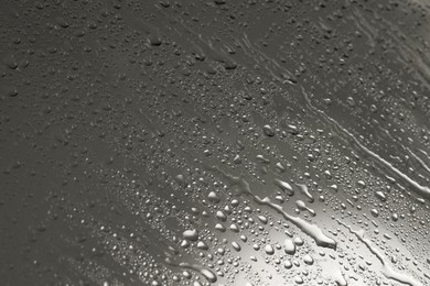 Water drops on grey glass surface, closeup