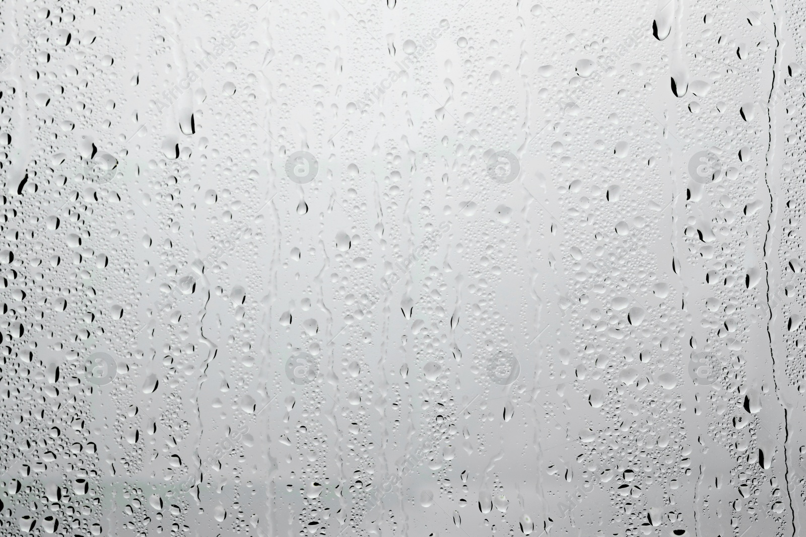 Photo of Water drops on light grey glass surface, top view