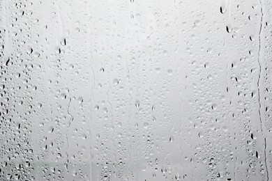 Photo of Water drops on light grey glass surface, top view