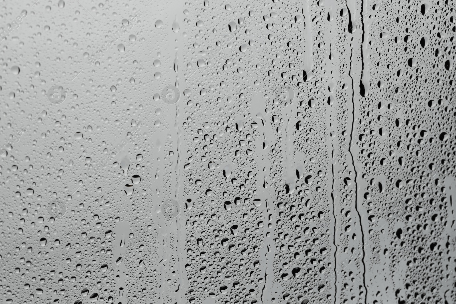 Photo of Water drops on grey glass surface, top view