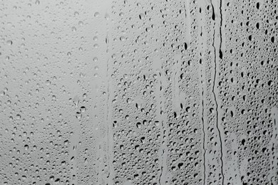 Photo of Water drops on grey glass surface, top view