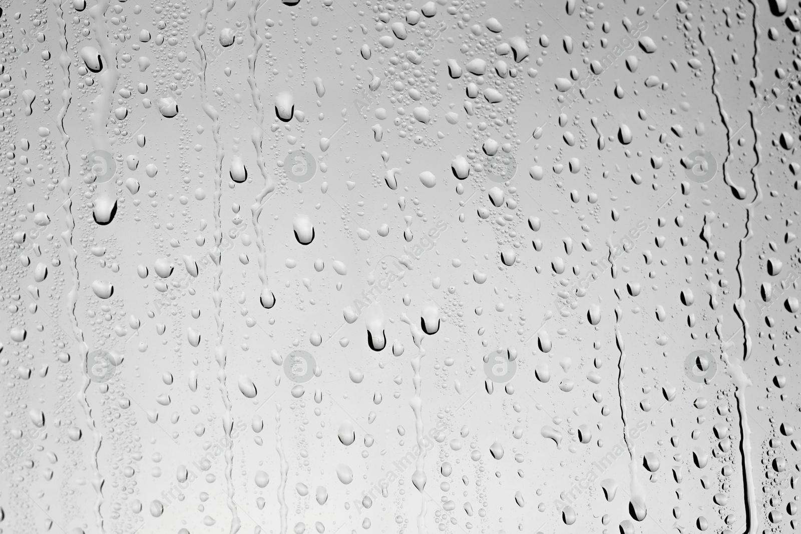 Photo of Water drops on grey glass surface, top view