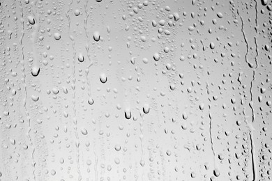 Photo of Water drops on grey glass surface, top view