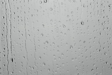 Photo of Water drops on grey glass surface, top view