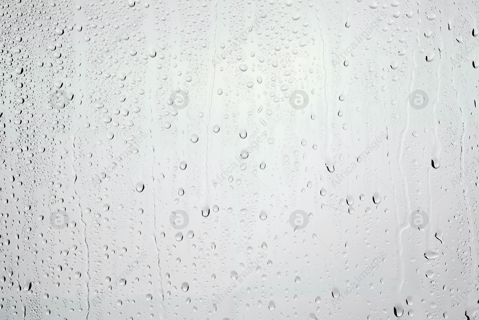 Photo of Water drops on light grey glass surface, top view