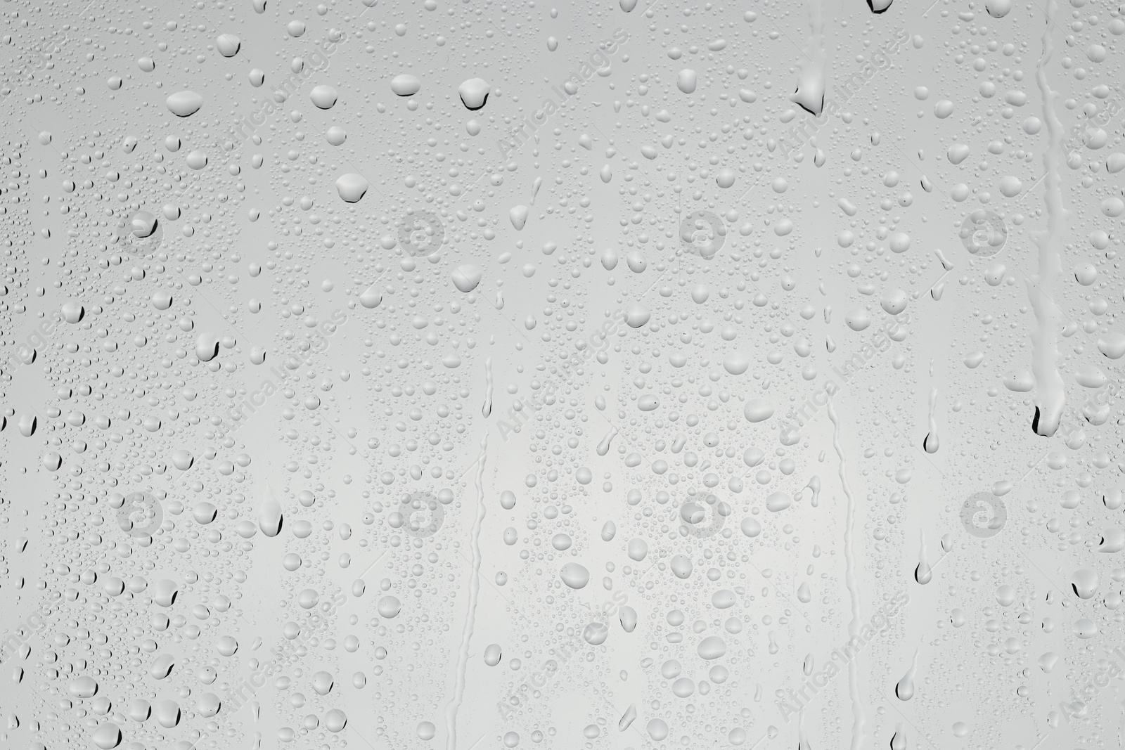 Photo of Water drops on light grey glass surface, top view