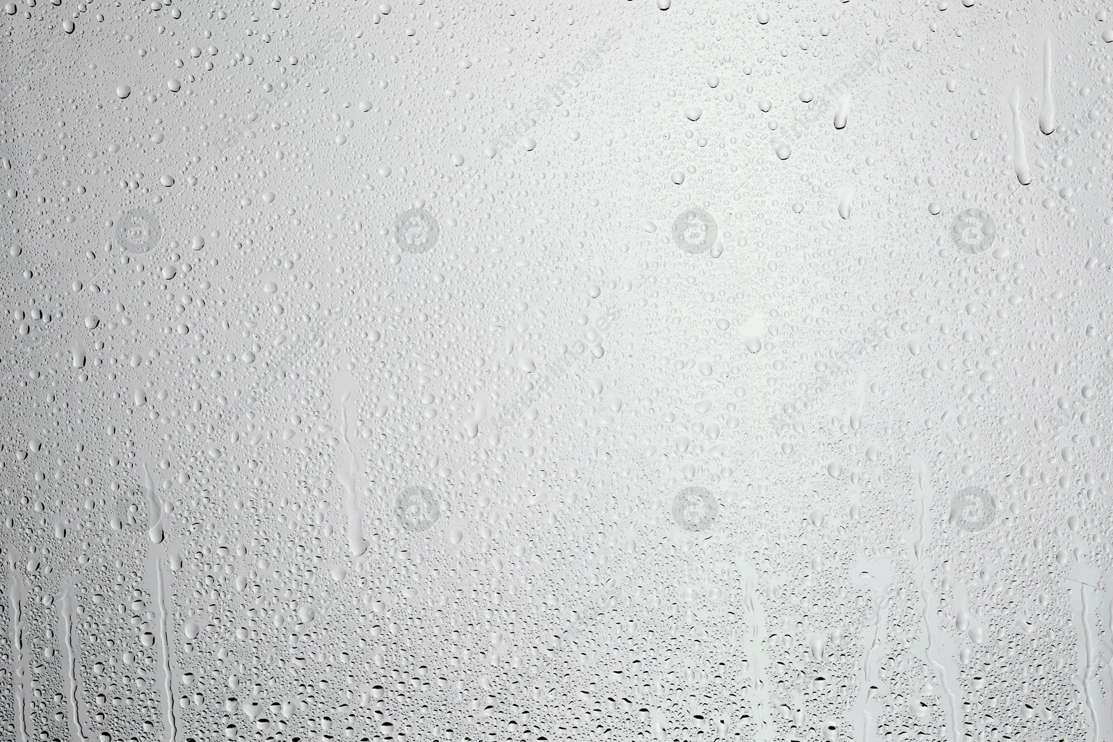 Photo of Water drops on light grey glass surface, top view