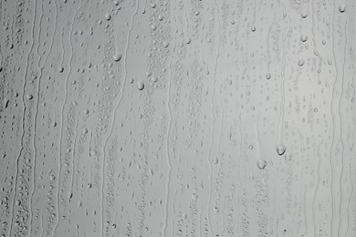 Water drops on grey glass surface, top view