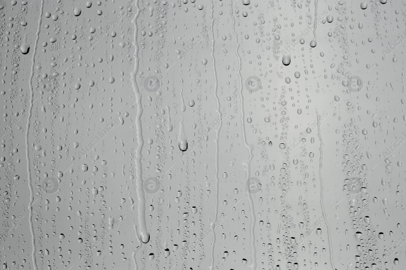 Photo of Water drops on grey glass surface, top view