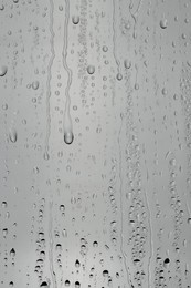 Photo of Water drops on grey glass surface, top view