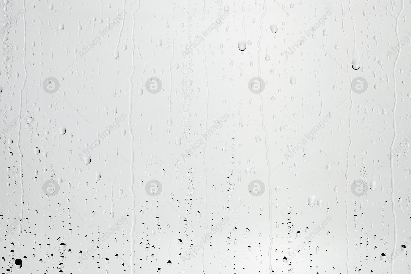 Photo of Water drops on light grey glass surface, top view