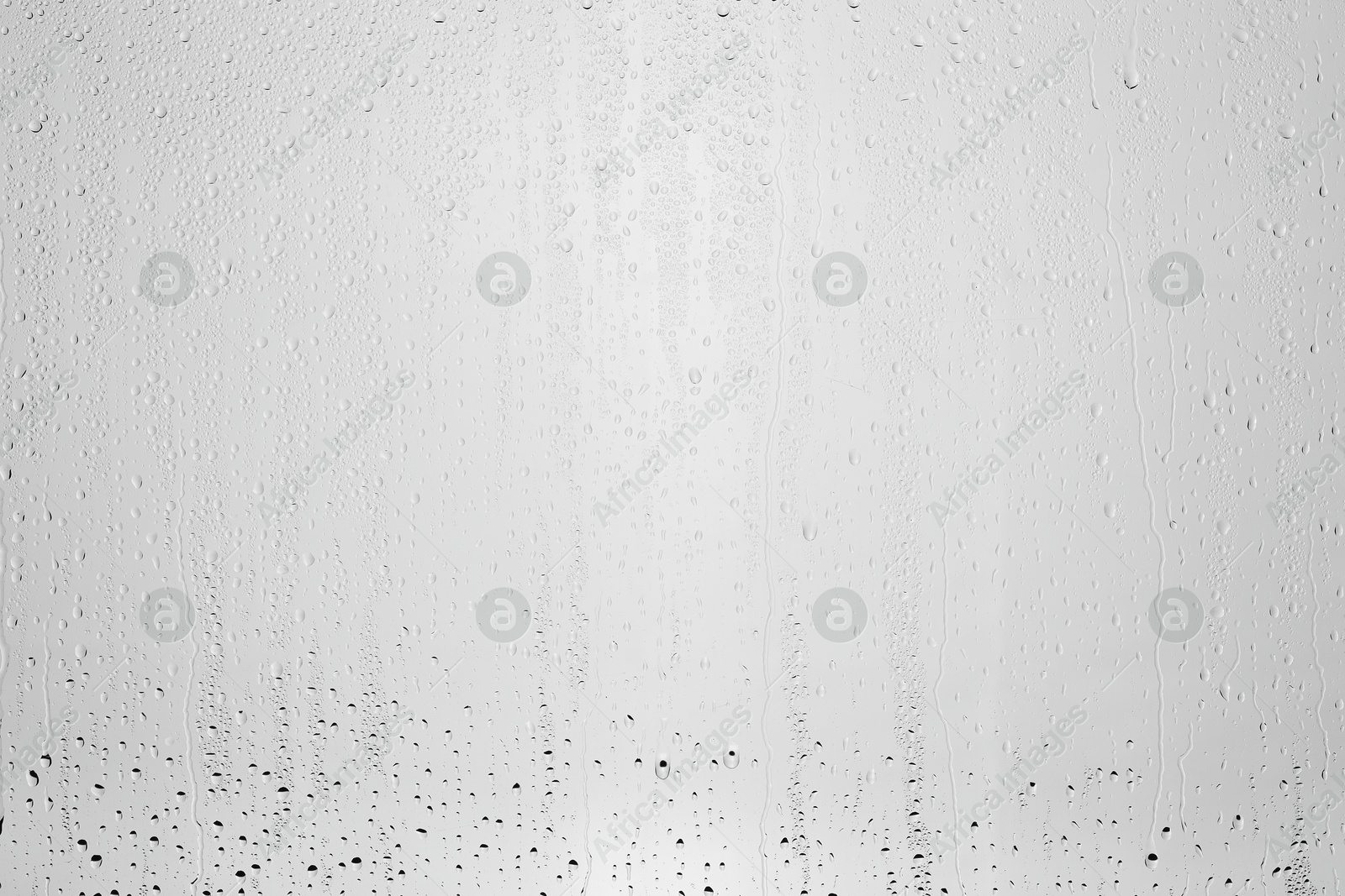 Photo of Water drops on light grey glass surface, top view