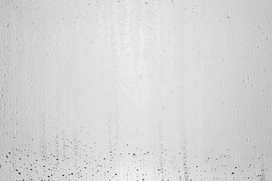 Photo of Water drops on light grey glass surface, top view