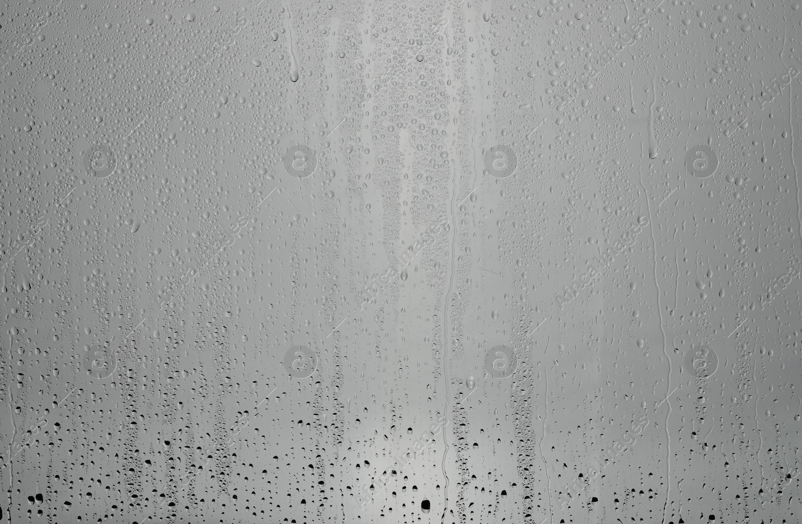 Photo of Water drops on grey glass surface, top view