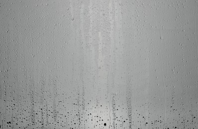 Water drops on grey glass surface, top view