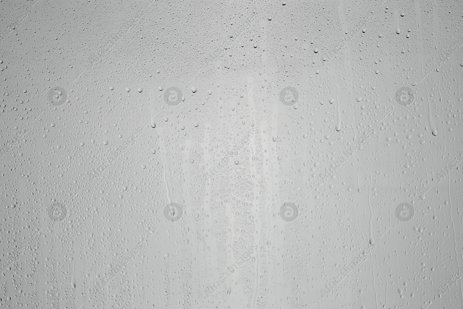 Photo of Water drops on grey glass surface, top view