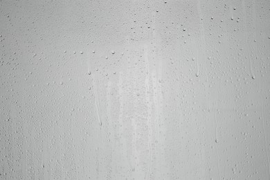 Water drops on grey glass surface, top view