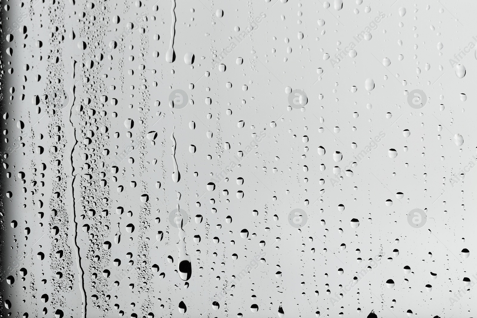 Photo of Water drops on light grey glass surface, top view