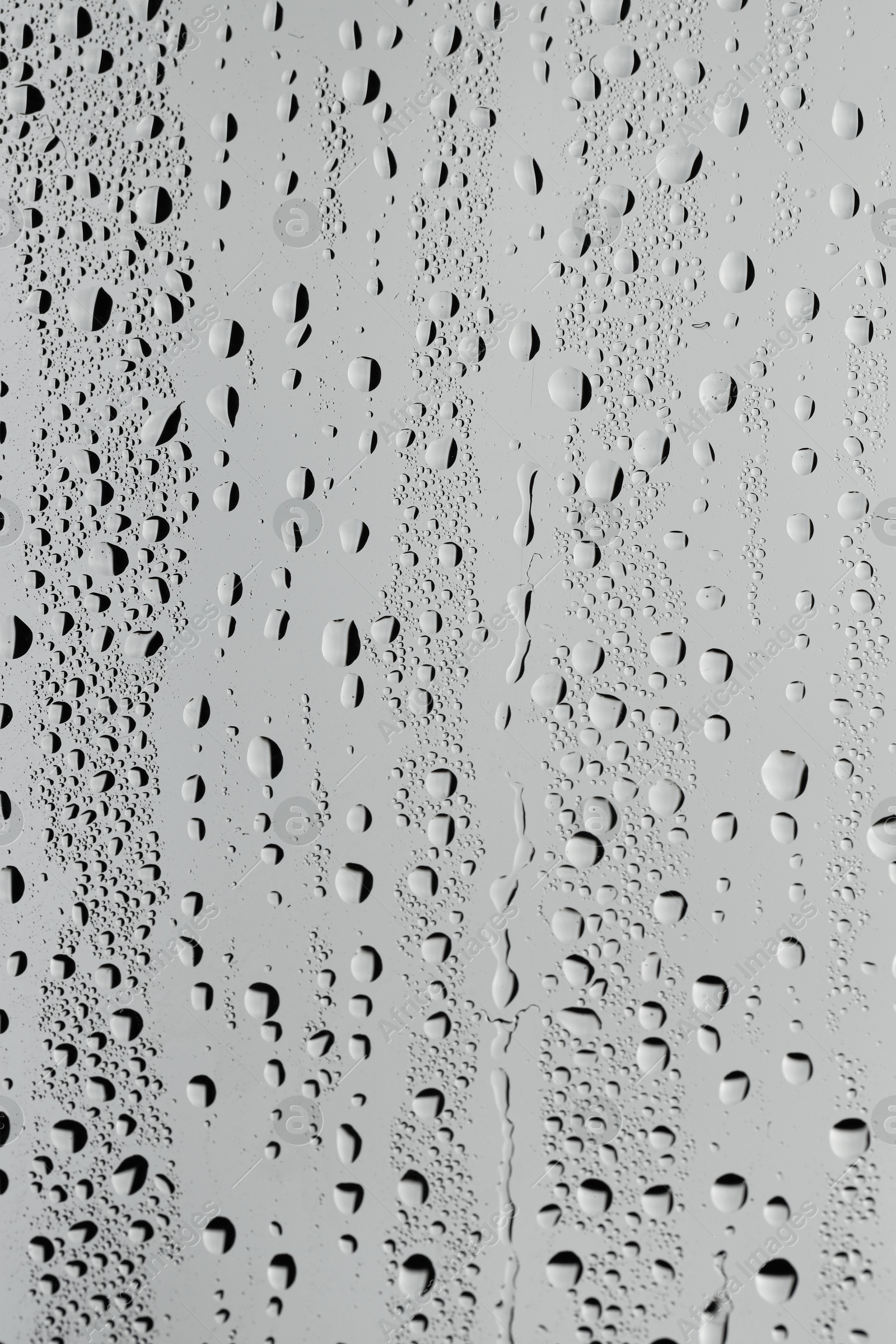 Photo of Water drops on grey glass surface, top view