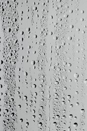 Water drops on grey glass surface, top view