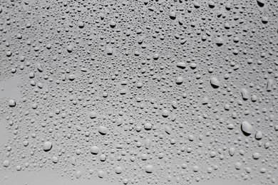 Water drops on grey glass surface, top view