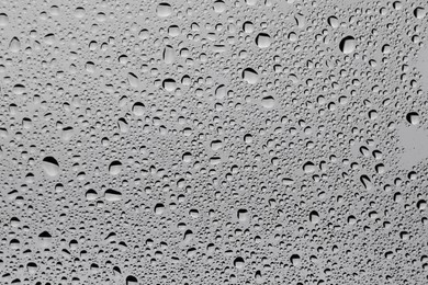 Water drops on grey glass surface, top view