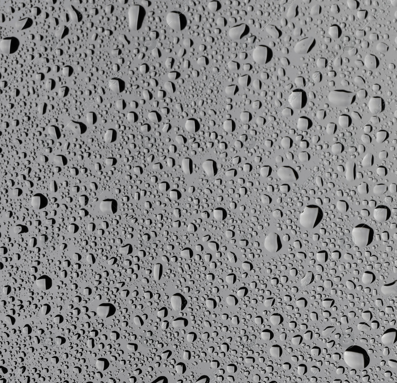 Photo of Water drops on grey glass surface, top view