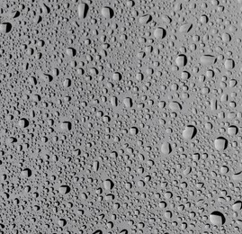 Photo of Water drops on grey glass surface, top view