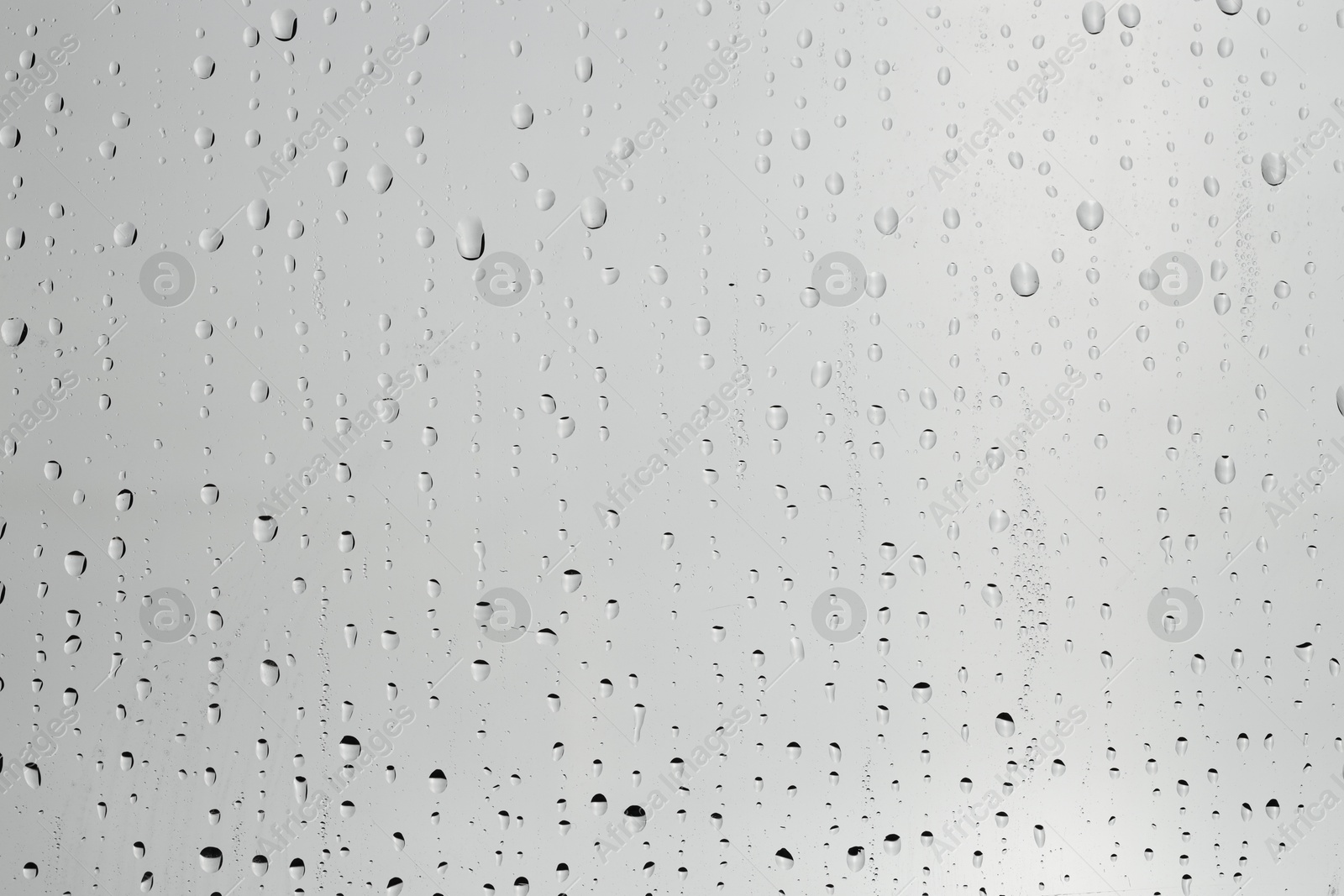 Photo of Water drops on light grey glass surface, top view