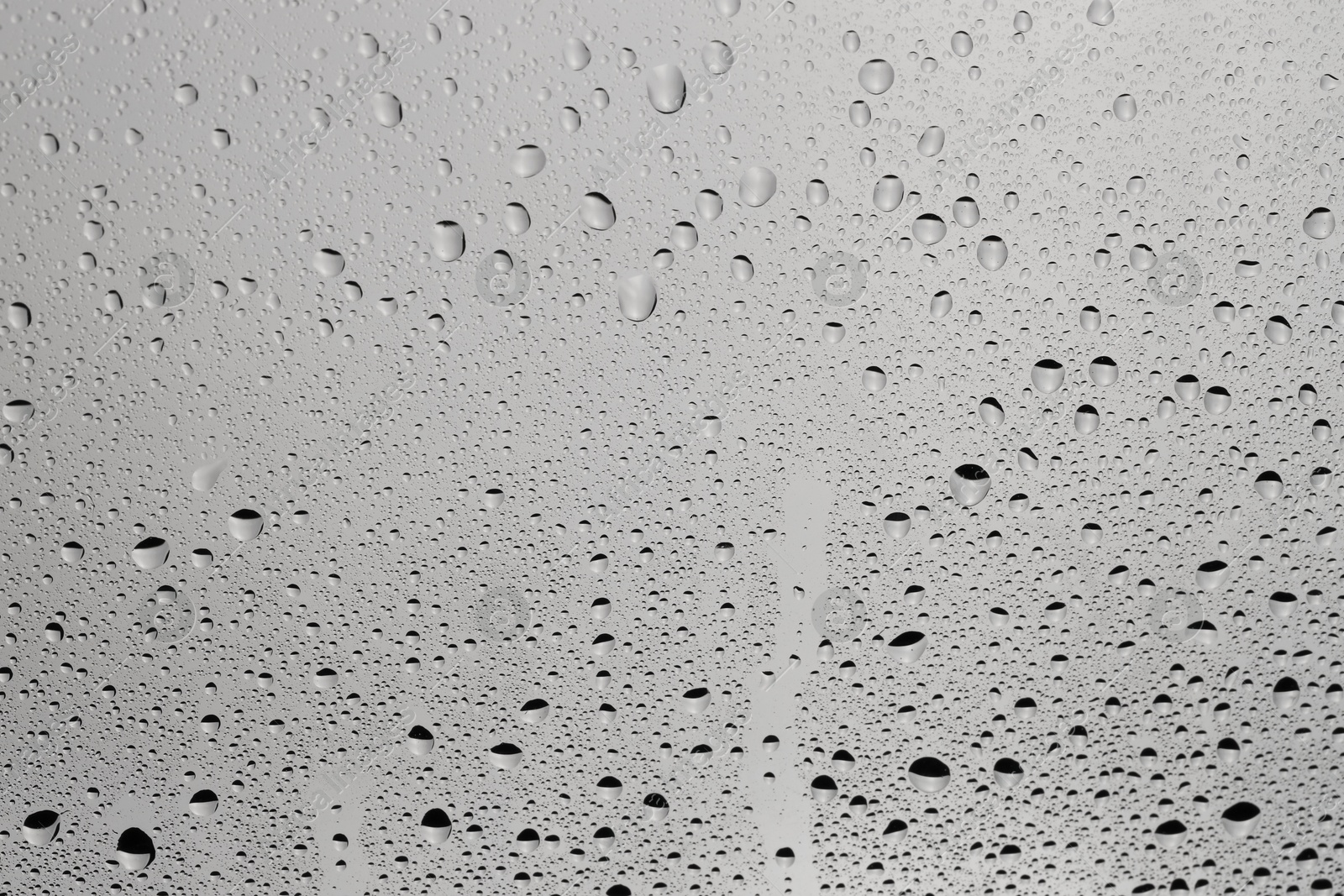 Photo of Water drops on grey glass surface, top view