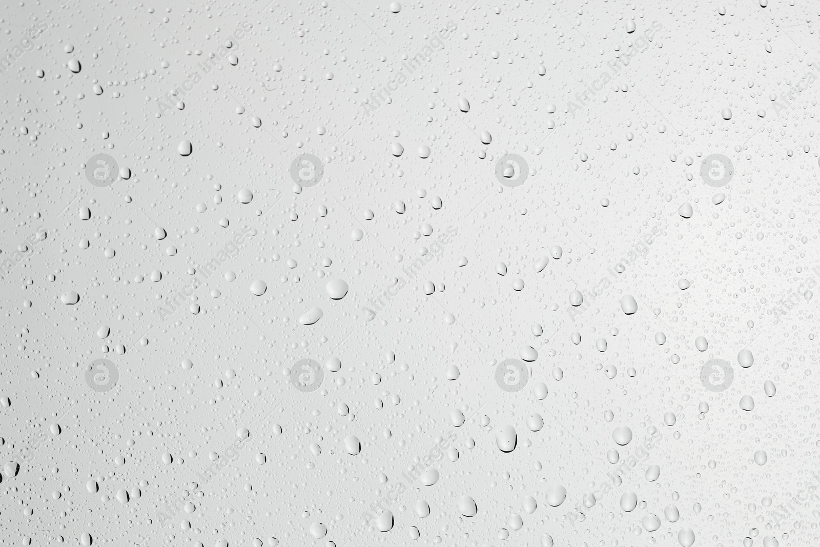 Photo of Water drops on light grey glass surface, top view